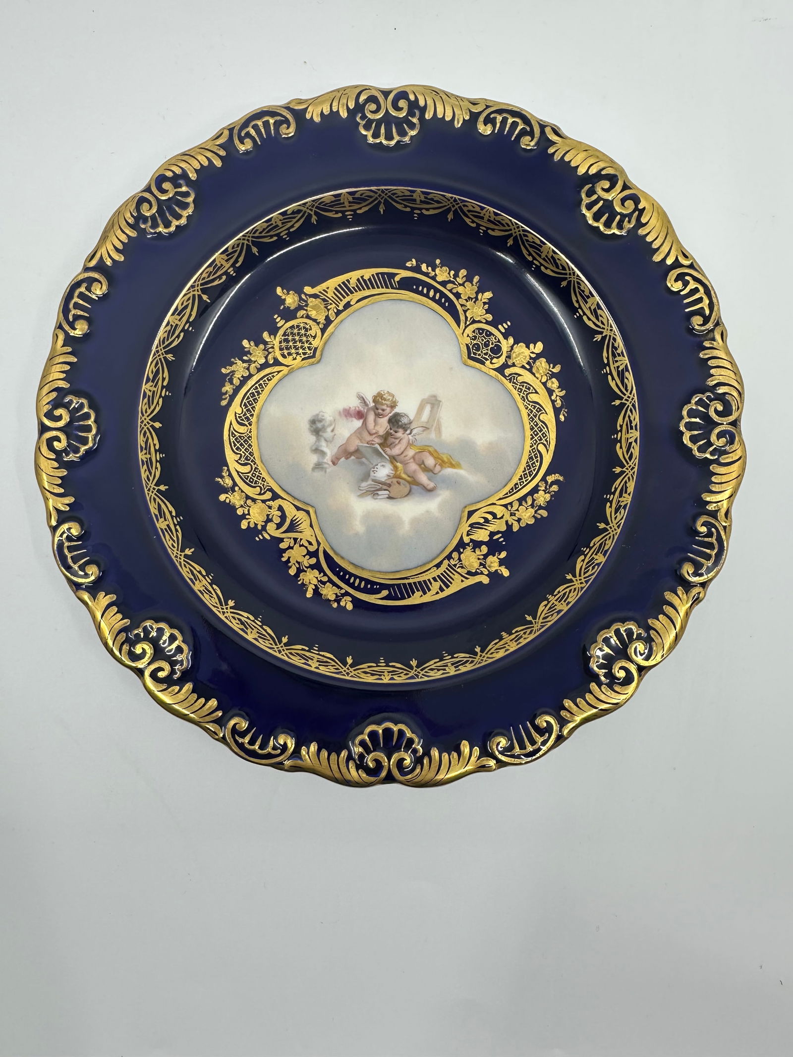 ANTIQUE MEISSEN PORCELAIN COBALT PLATE: DescriptionANTIQUE MEISSEN PORCELAIN COBALT PLATE. LATE 19TH, BLUE CROSSED SWORDS MARK, IMPRESSED marks. Finely painted putto scenes, gilt line rim 9 in. (23.4 cm.) diameter