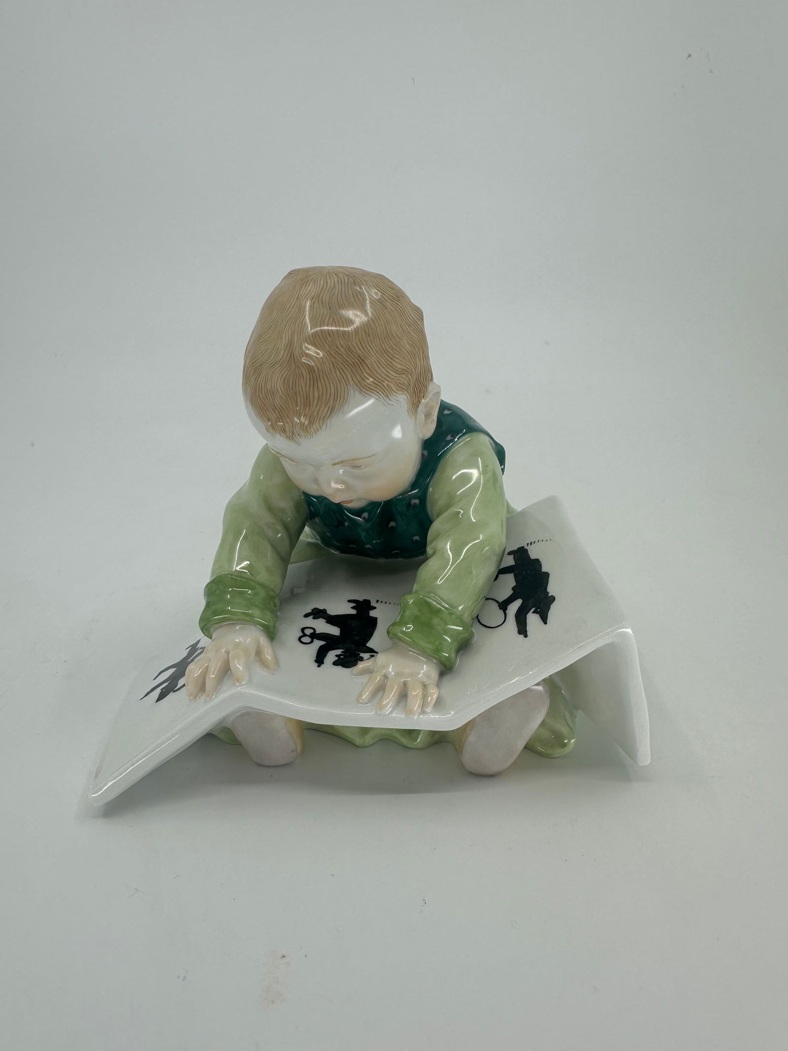 Anitque Meissen Porcelain Baby Reading a Book, by Konrad Hentschel: A Meissen Porcelain Baby Reading a Book, by Konrad Hentschel Early 20th Century with blue underglaze mark and incised number 73354 and 952 height 4 1/8 inches Condition: Excellent Condition. We Ship W