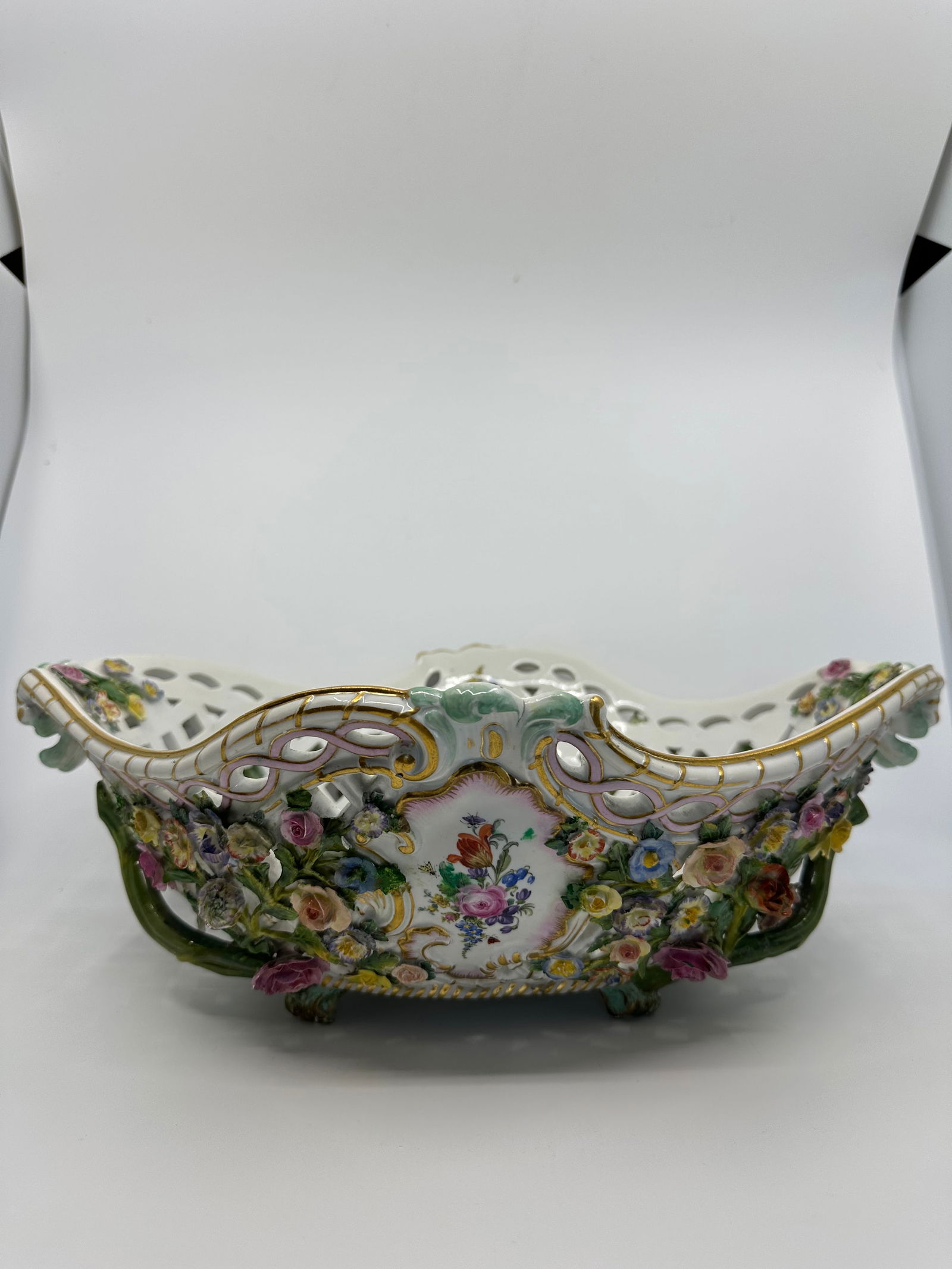A MEISSEN FLOWER-ENCRUSTED BASKET: A MEISSEN FLOWER-ENCRUSTED BASKETCIRCA 1870, BLUE CROSSED SWORDS MARKS AND INCISED E152Of lozenge form, the pierced sides applied with trailing flowers and leaves, framing two rocaille-moulded cartouc