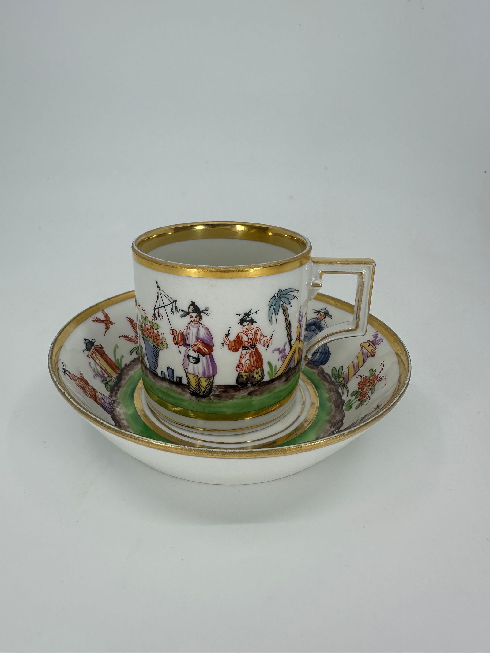 Antique Meissen Chinoiserie cup and saucer: A Meissen (Marcolini) cup and saucer, painted in colours with flowers forming, blue crossed swords and star mark, circa 1800 -- 3in. high; cup and saucer painted in a Chinoiserie style