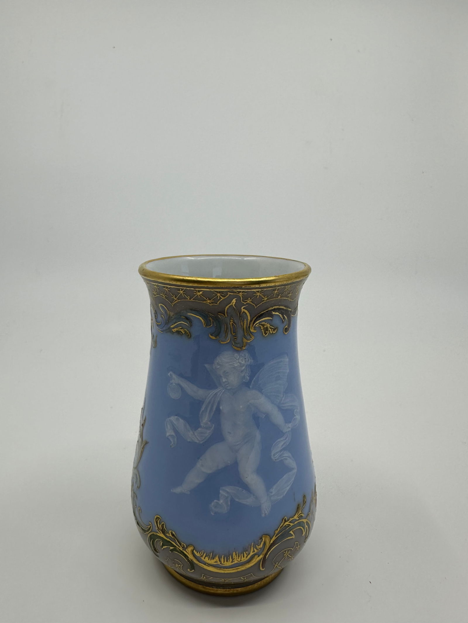 A MEISSEN PORCELAIN PALE-BLUE GROUND PATE-SUR-PATE VASE: A MEISSEN PORCELAIN PALE-BLUE GROUND PATE-SUR-PATE VASECIRCA 1880, BLUE CROSSED SWORDS MARK, IMPRESSED MODEL NO. finely painted and hand-tooled in white slip with a scantily draped cupid holding a spr