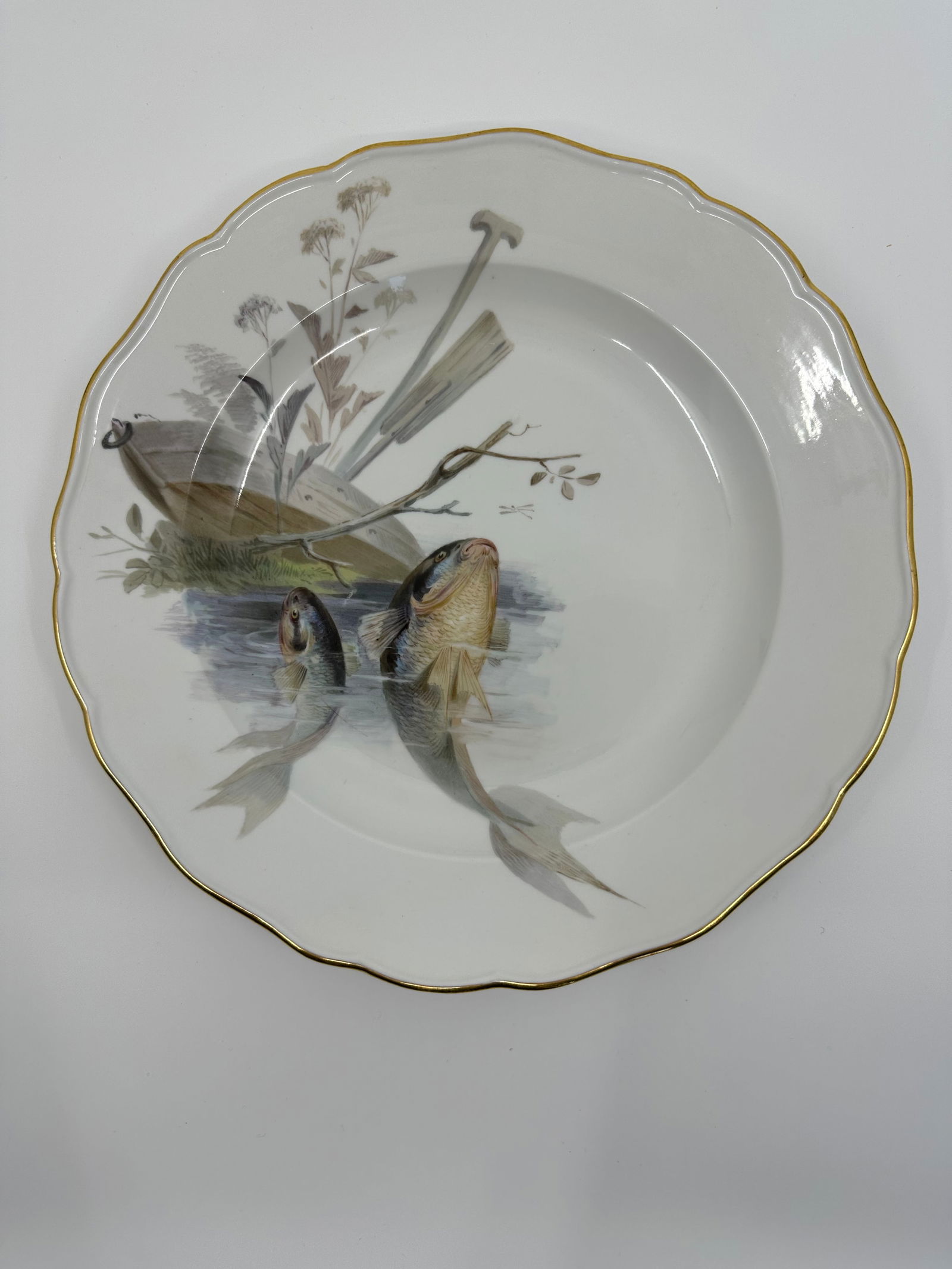 Antique Meissen porcelain fish plate: Each plate is individually decorated with a different type of fish swimming with varied items in the background including, ships, fishing boats, barrels, dock fragments, baskets, and landscape. All pi