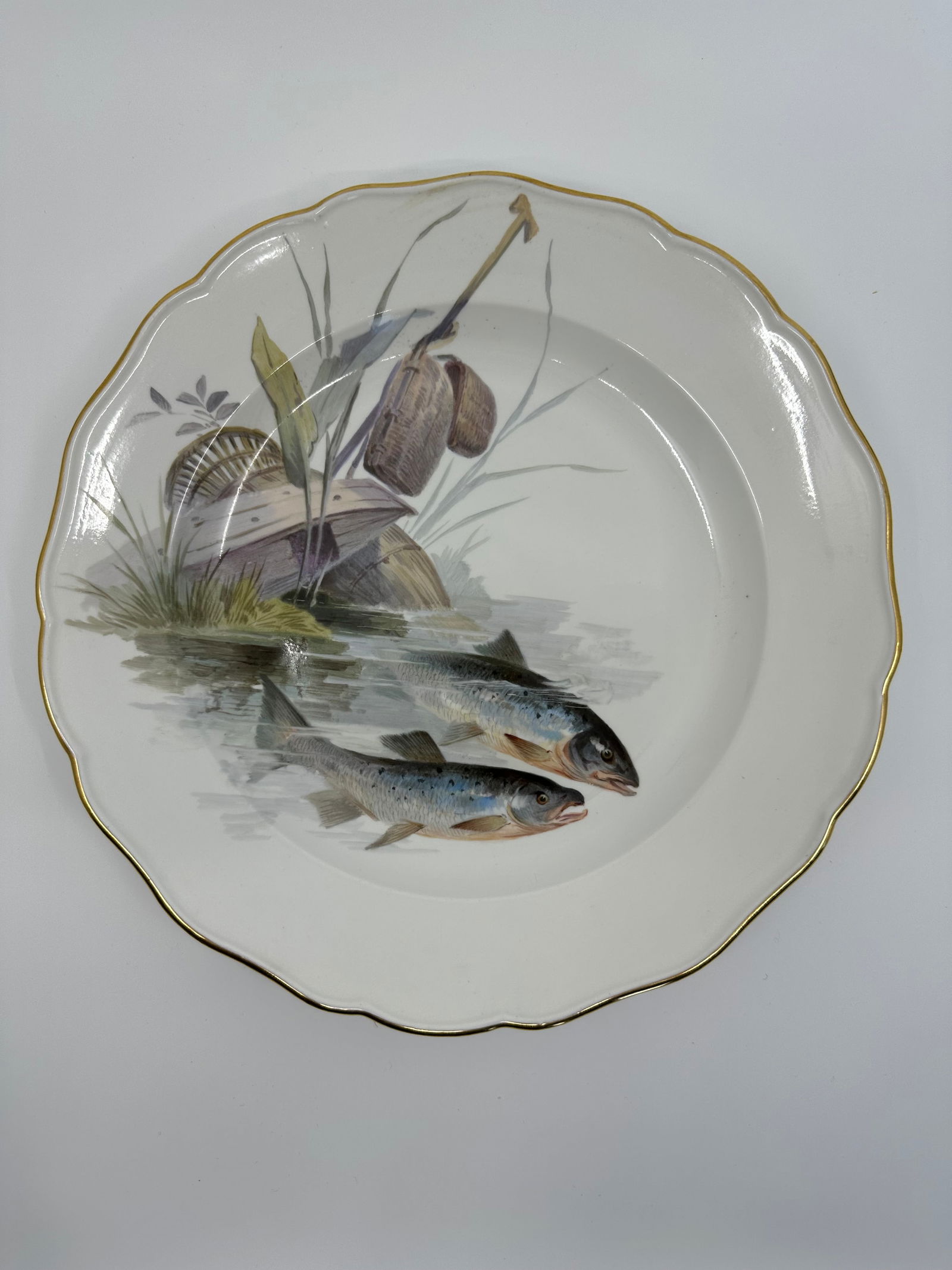 Antique Meissen porcelain fish plate: Each plate is individually decorated with a different type of fish swimming with varied items in the background including, ships, fishing boats, barrels, dock fragments, baskets, and landscape. All pi
