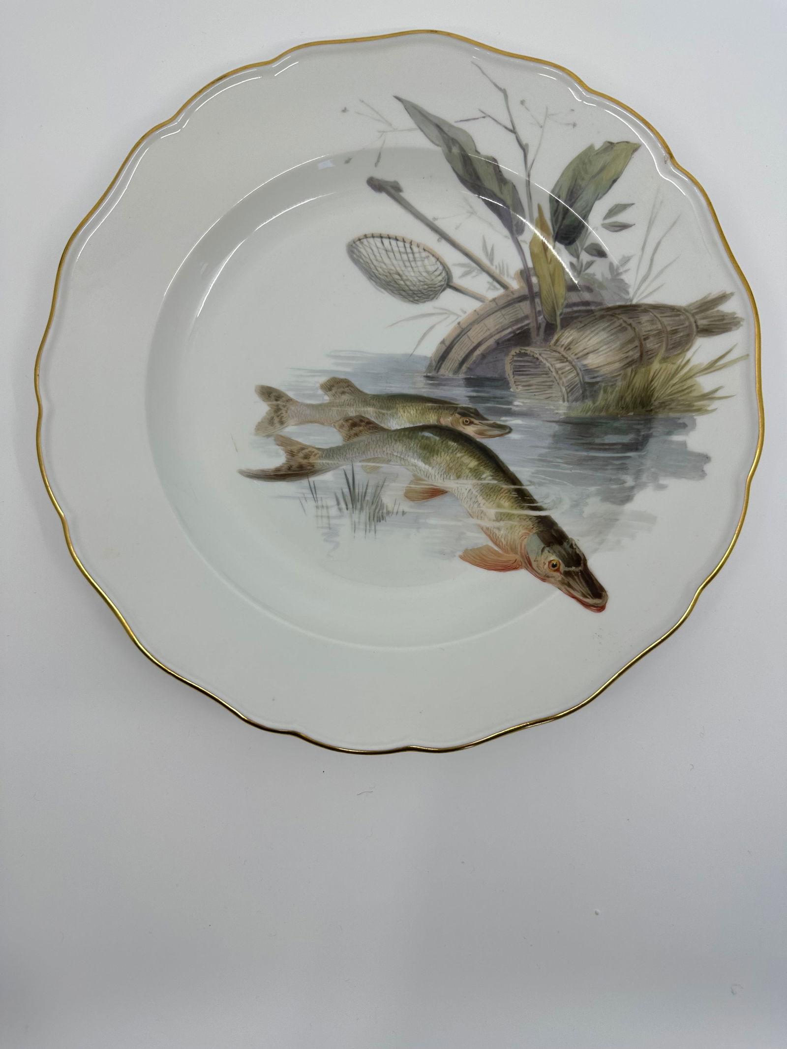 Antique Meissen porcelain fish plate: Each plate is individually decorated with a different type of fish swimming with varied items in the background including, ships, fishing boats, barrels, dock fragments, baskets, and landscape. All pi