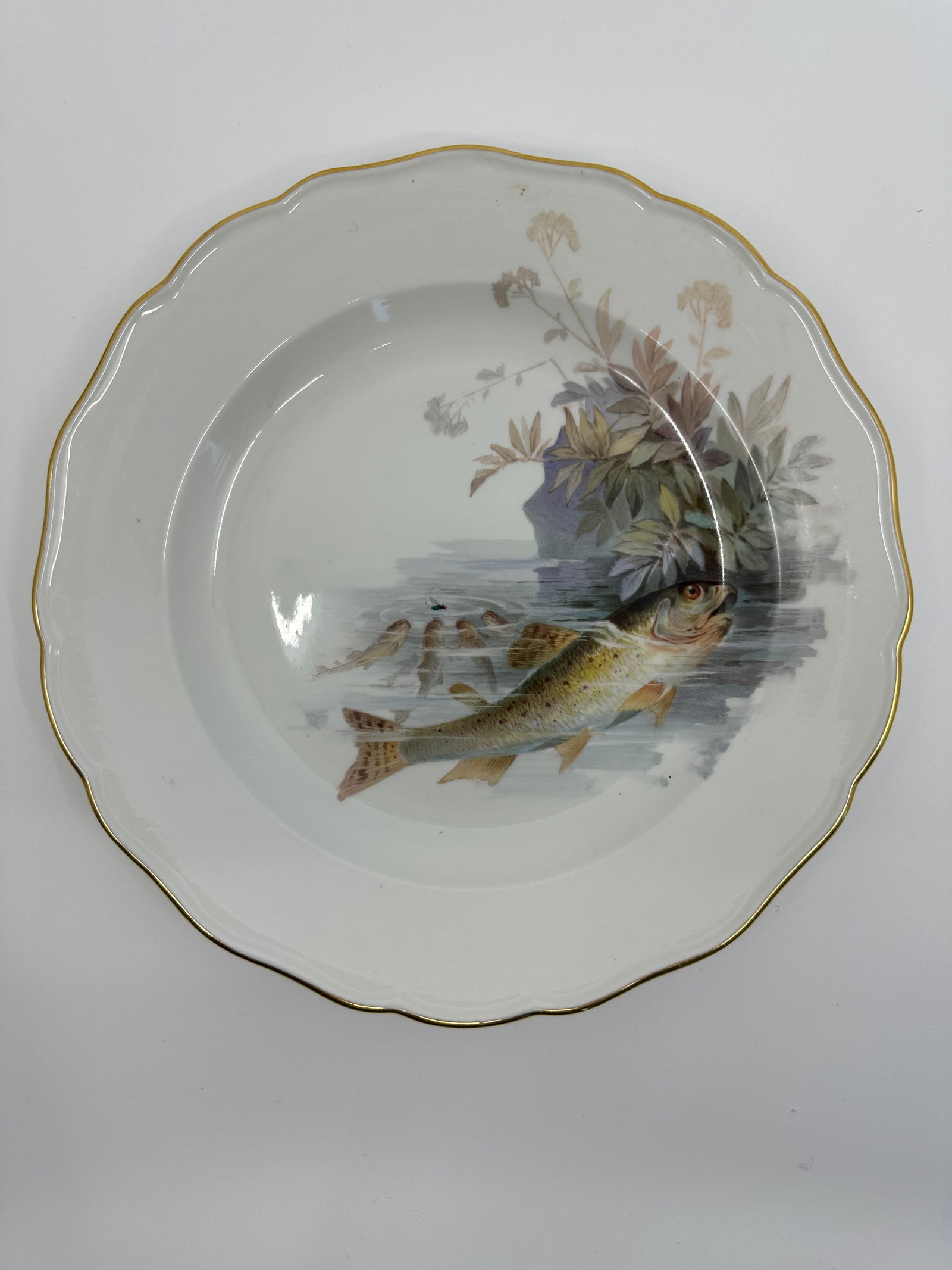 Antique Meissen porcelain fish plate: Each plate is individually decorated with a different type of fish swimming with varied items in the background including, ships, fishing boats, barrels, dock fragments, baskets, and landscape. All pi