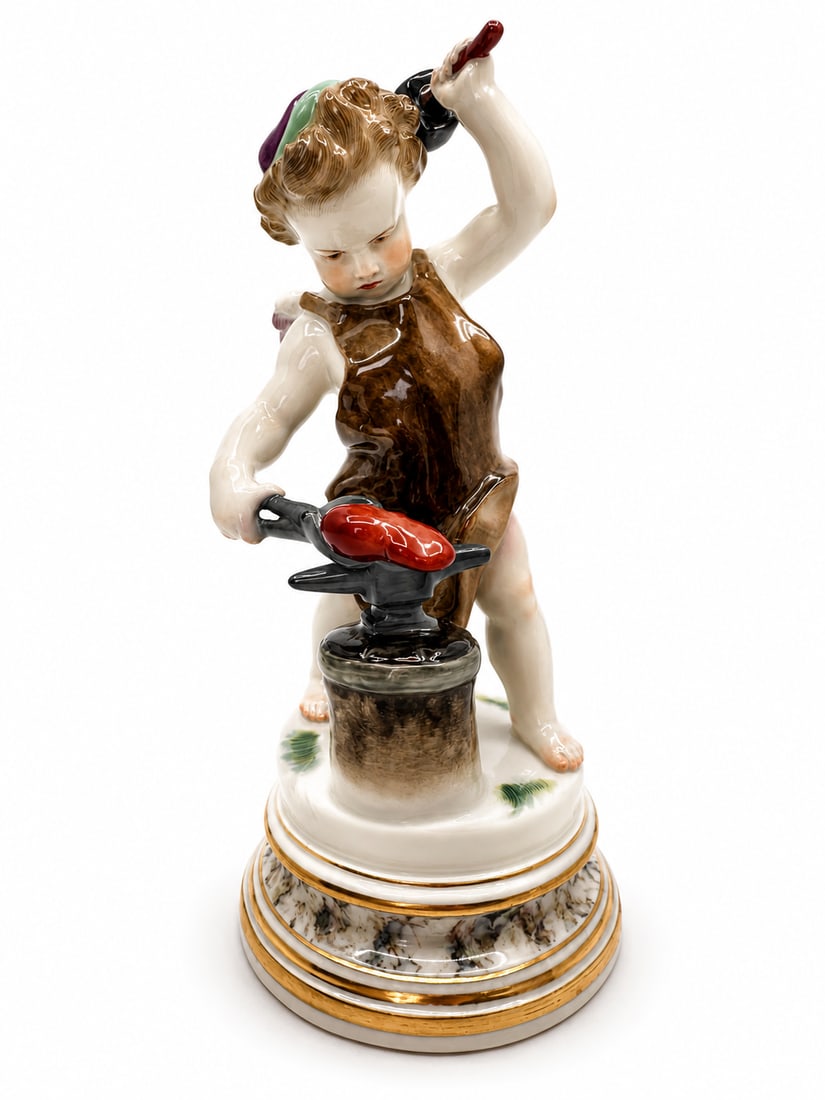 A MEISSEN FIGURE OF CUPID AS A BLACKSMITH: wearing a cap and a leather apron, pursing his lips in a scowl of fury as he raises a mallet in his left hand to strike a heart clasped in a pair of pincers on an anvil and stump support, standing on 