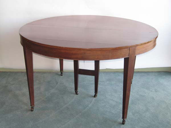 207: Round Mahogany Dining Table: Round Mahogany Dining Table having a cockbead molded apron, square tapered legs that end in casters. 30"h, 54"dia, 6 leaves 11"w each. With all leaves 10'l. Some major dings in table and overall wear