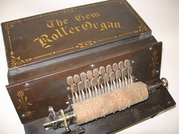 316: A 19th C "The Gem Roller Organ": A 19th C "The Gem Roller Organ" with an ebonized and gilt stenciled cabinet and four rolls. 8" h, 14 1/4" w, 15" d (including the crank handle).