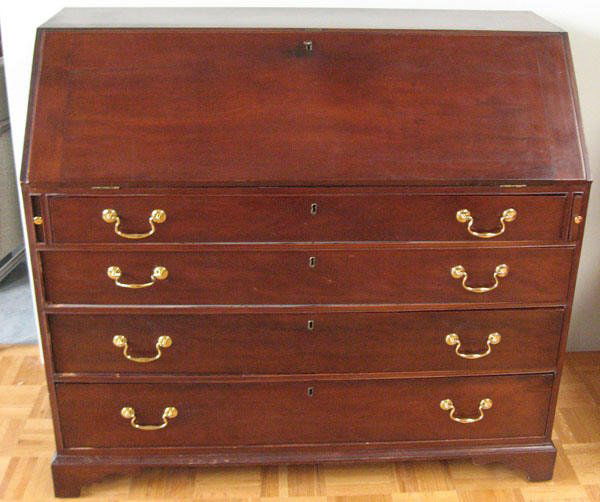 An Early Mahogany Slant Front Desk,: with a fitted interior behind the slant front, breadboard ends to the slant, over four graduated drawers with brass pulls, resting on a bracket foot base. 40 1/2" high, 44 1/2" wide, 20 1/2" deep. Age