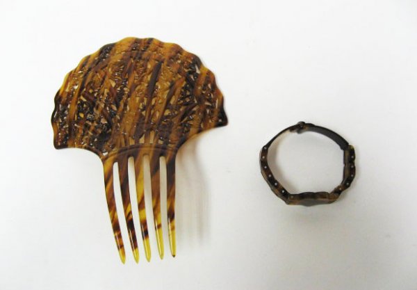An Elaborate Hair Comb and Bracelet,: both of tortoise shell, the comb having a pierced foliate and scrolled fan design, 6 1/2" high, 4 3/4" wide; the bracelet of a hinged bar design with a heart center and watch strap closure.