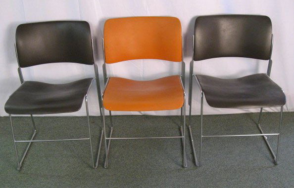 Three David Rowland Chairs, model 40/4: two brown, one orange, with paper tag. Dated 1980.