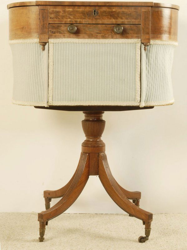 A New England Federal Sewing Stand, c. 1800-1820,: c. 1800-1820, in the Duncan Phyfe taste, mahogany with white pine secondary, having a shaped lift top revealing an adjustable writing surface with a pen holder and smaller compartments, over a deep dr