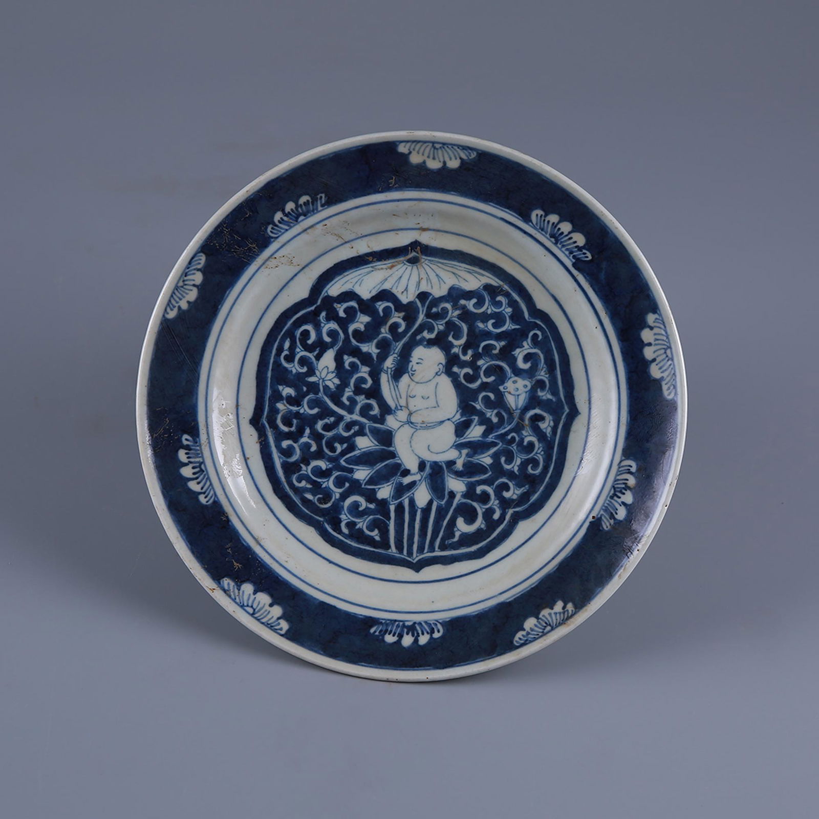 A blue and white boy holding a lotus pattern plate in (1 of 8)