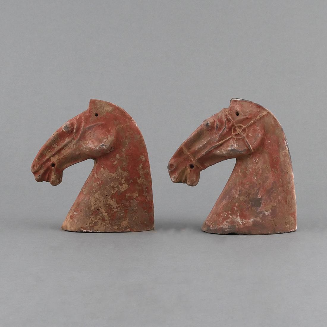 A PAIR OF PAINTED RED POTTERY HORSE HEADS (1 of 9)