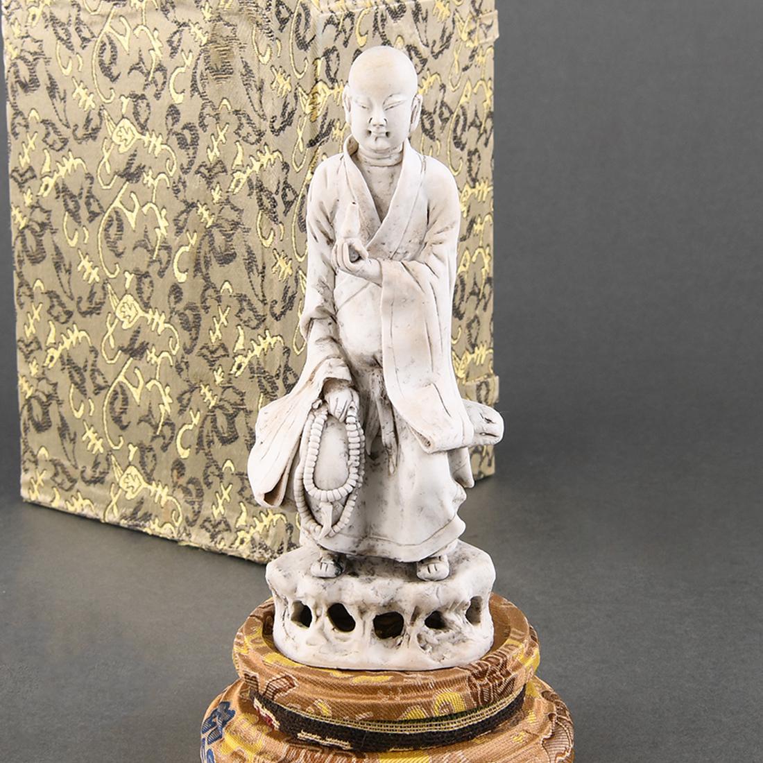 A 'QINGBAI' BISCUIT FIGURE OF A LUOHAN (1 of 9)