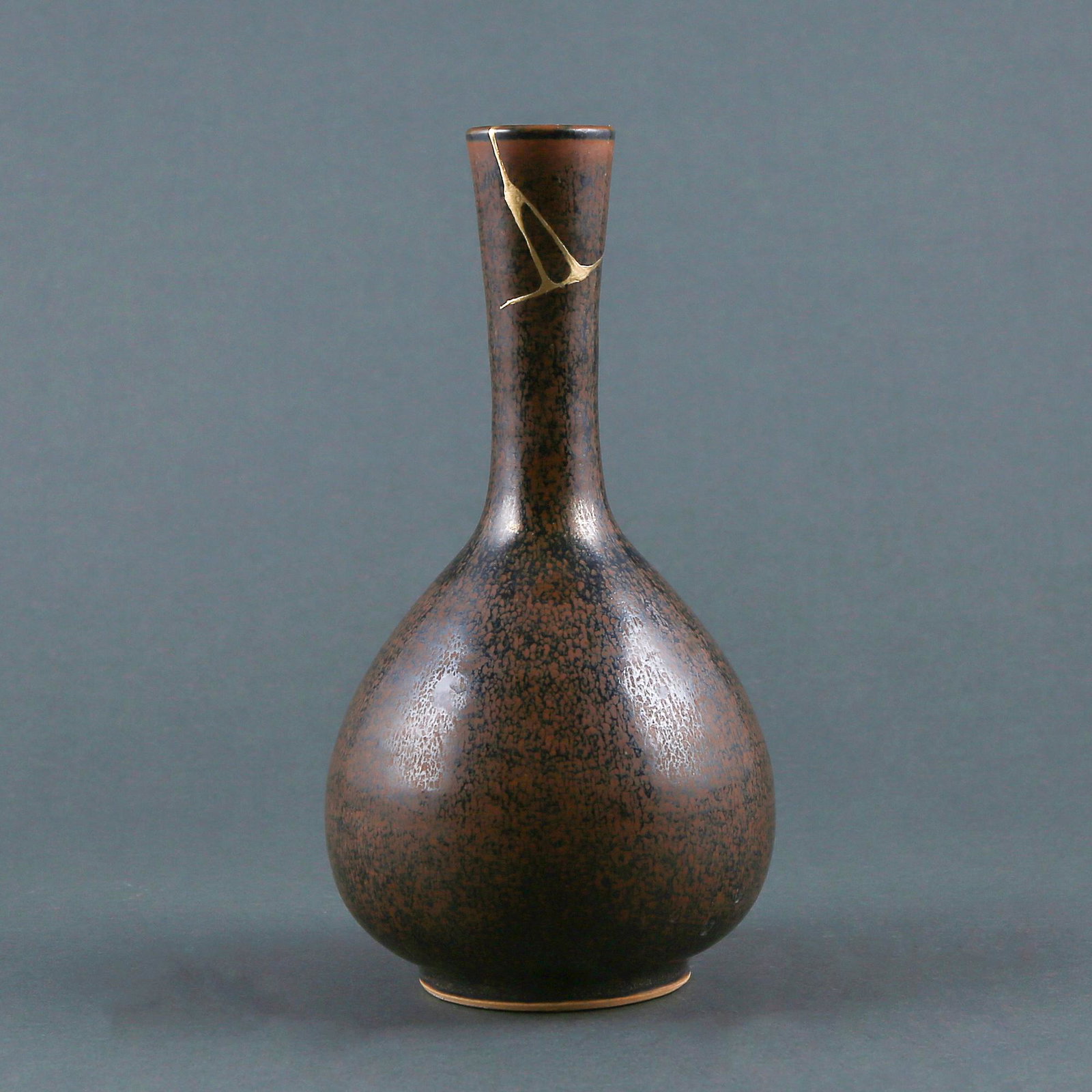 A 'CIZHOU' BLACK GLAZE KILN CHANGED FLASK: A 'CIZHOU' black glaze kiln changed flask (JINSHAN) later applied with Japanese kintsugi restoration Size:H:23.1cm,W:12.2cm,Diam.of mouth:3.9cm