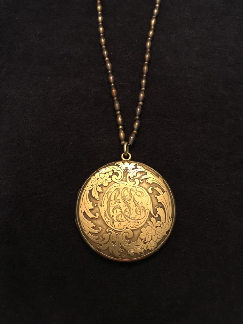 Antique Art Nouveau Gold-filled Locket: A double frame, circular gold-filled locket. Front features a repousse naturalistic art nouveau motif of flowers and leaves, surrounding a central monogram (“CLS”). 2” in diameter, 49.30 g. With