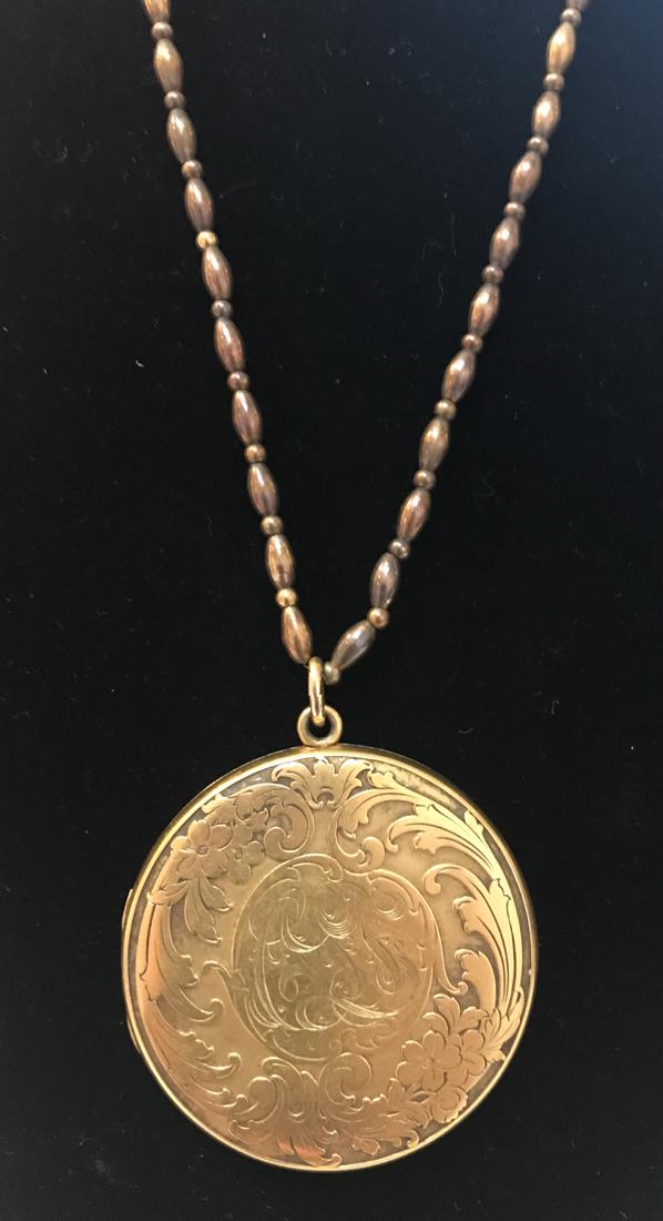 Antique Art Nouveau Gold-filled Locket: A double frame, circular gold-filled locket. Front features a repousse naturalistic art nouveau motif of flowers and leaves, surrounding a central monogram (â€œCLS”). 2” in diameter, 4
