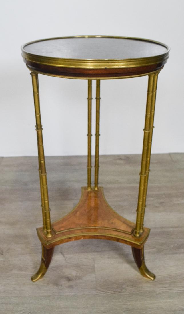 Louis XVI Style Gueridon Table: Gilt-Bronze, Marble and Burlwood. In the manner of Adam Weisweiler. Circular top raised on ring turned supports joined by shaped stretchers and ending is scroll feet. Height 27.5" diameter 15"