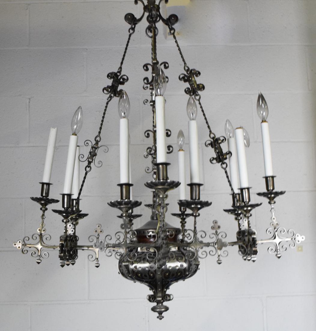 Renaissance Style Iron 12 Light Chandelier: Wrought iron pierced body with straight branches. Scrolls terminating in "T" form candle holders. Height 37" diameter 29"