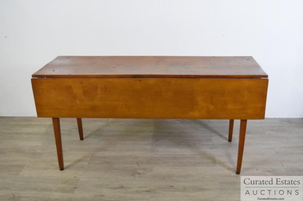 Shaker Style Drop leaf Table: Shaker Style drop leaf table. Legs attached with pegs in tenons. Cupping to table top do to age. Please see photos. Dimensions: 56" L x 19" W x 27 1/2 " H Provenance: From the Estate of Elaine Steinbe