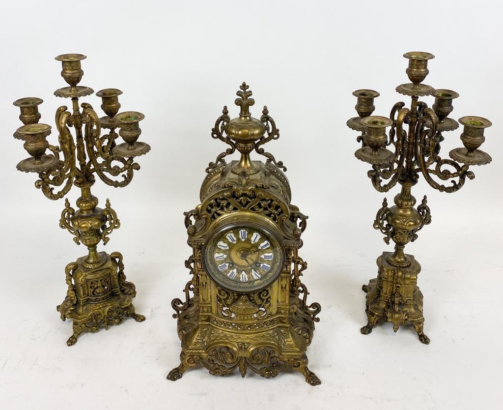 C Cellier Gilt Bronze Mantel Clock & Garniture: Renaissance revival style gilt bronze mantel set, France, c. 1880 A clock with an elaborate bronze case, with crown, over circular face, with blue roman numerals on white enamel. Has pendulum, key, an