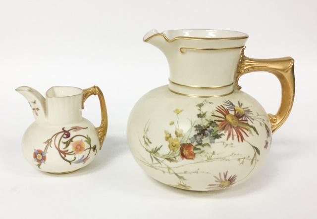 2 Royal Worcester Porcelain Pitchers: Hand painted floral motif on both. Both with gold gilt handles. Larger 6"H