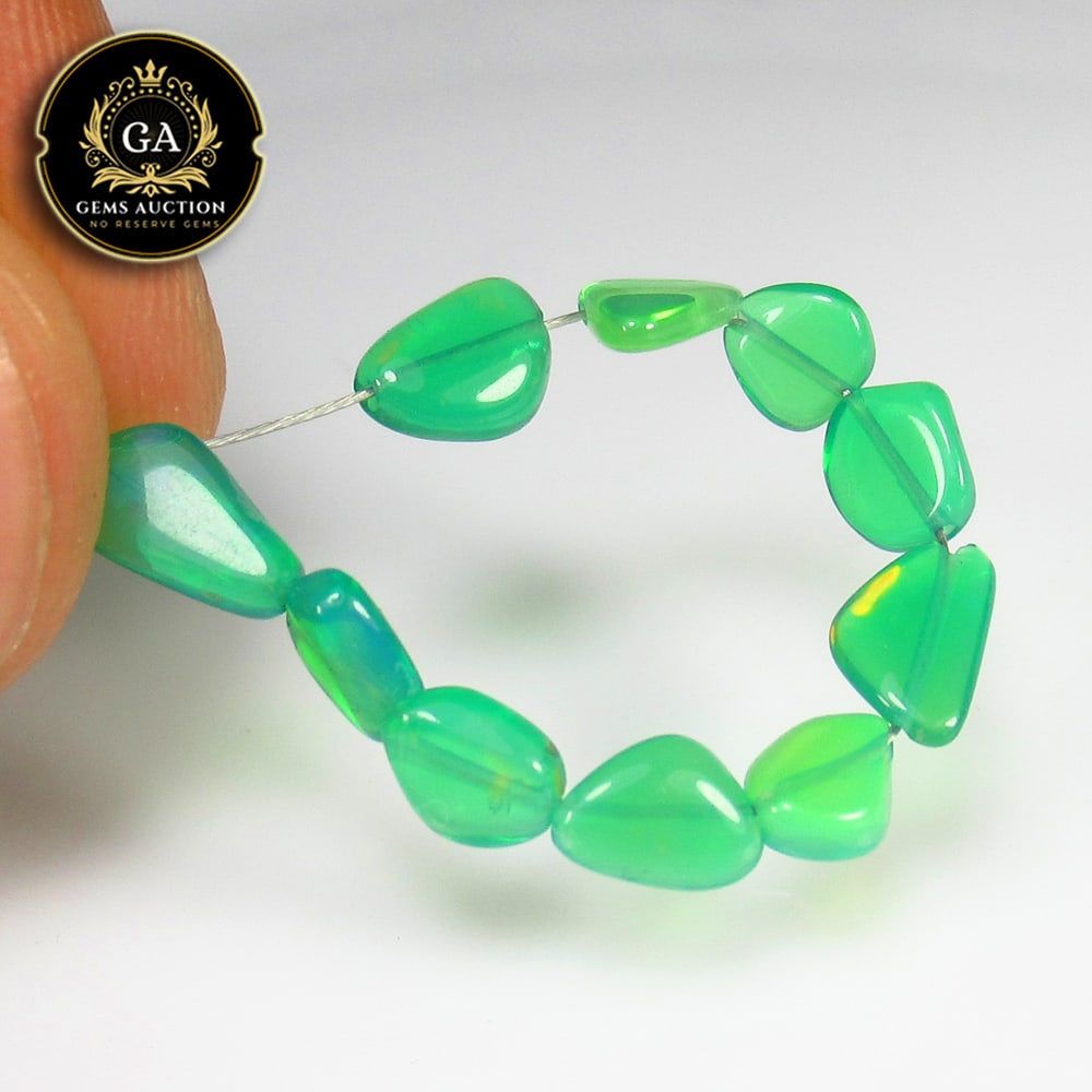 2.65 Ct Natural 10 Drilled Green Fire Opal Unshaped Beads: Weight - 2.65 Ct / Size - 6.3x5.2 to 7.5x4.3 mm / Pices - 10 No's / Shape - Drilled Unshaped Beads / Color - Green / Clarity - Transparent / Origin - Ethiopia / Treatment - Color Heated