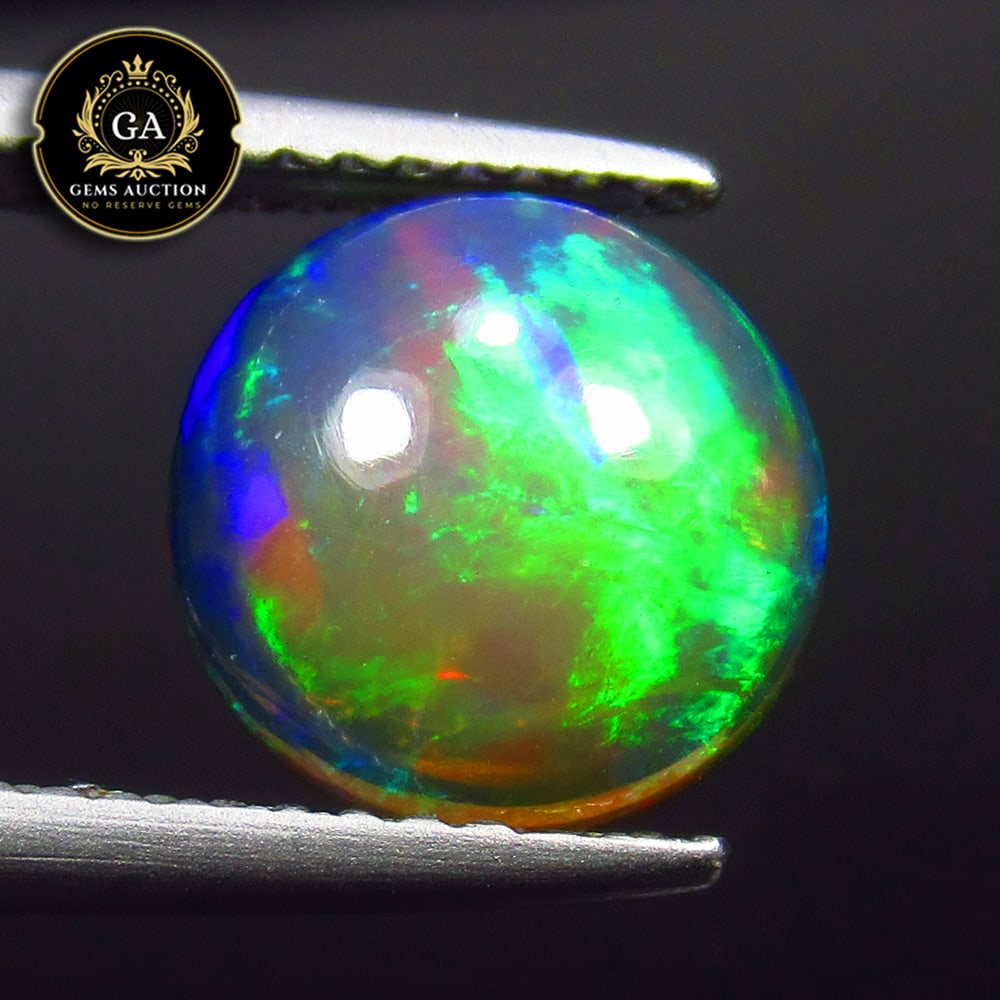 1.73 Ct Natural Black Flashing Fire Opal Round Cab: Weight - 1.73 Ct / Size - 9.00 x 9.00 x 4.20 mm / Shape - Round Cab / Color - Black / Clarity - Translucent / Origin - Ethiopia / Treatment - Heated