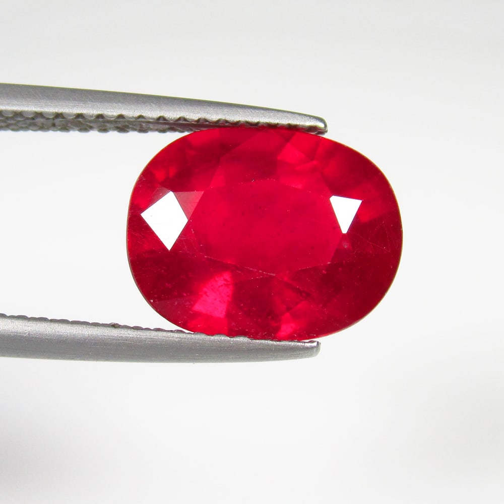 5.74 Ct Natural Pinkish Red Ruby Oval Cut: Weight - 5.74 Ct / Size - 11.70 x 9.10 x 6.10 mm / Shape - Oval Cut / Color - Red / Clarity - SI / Origin - Mozambique / Treatment - Color Enhanced by Glass Filling