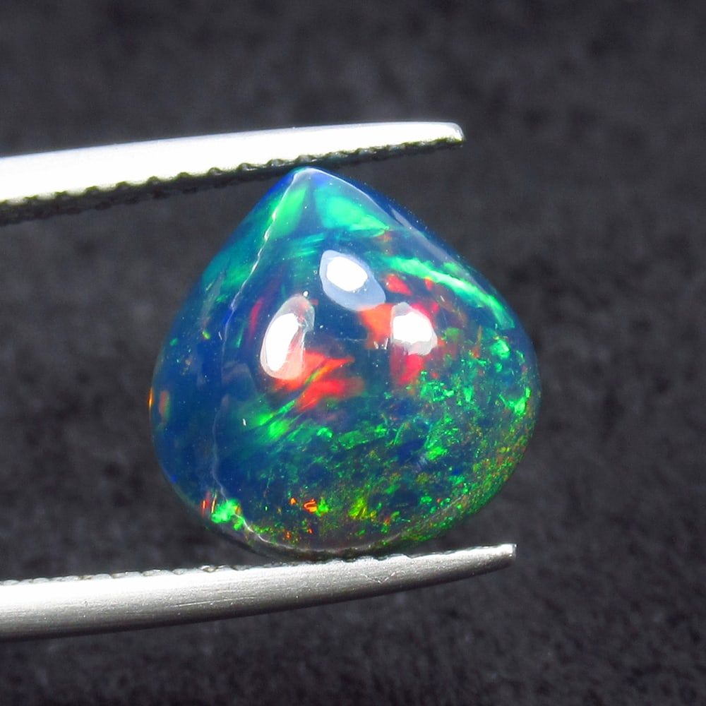 3.58 Ct Natural Black Flashing Fire Opal Pear Cab: Weight - 3.58 Ct / Size - 11.30 x 11.10 x 7.10 mm / Shape - Pear Cab / Color - Black / Clarity - Translucent / Origin - Ethiopia / Treatment - Color Smoked