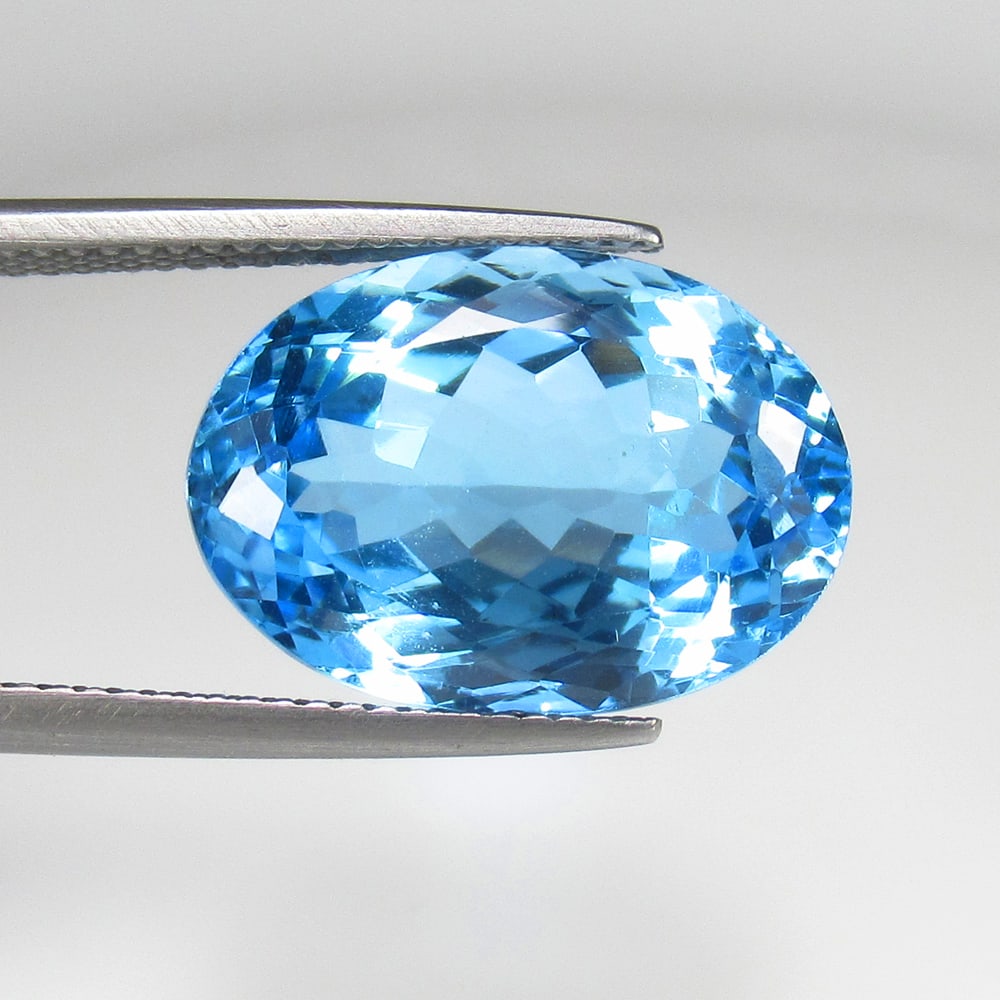 14.02 Ct Natural Blue Topaz Oval Cut: Weight - 14.02 Ct / Size - 17.40 x 12.40 x 8.10 mm / Shape - Oval Cut / Color - Blue / Clarity - VVS / Origin - Brazil / Treatment - Irradiated