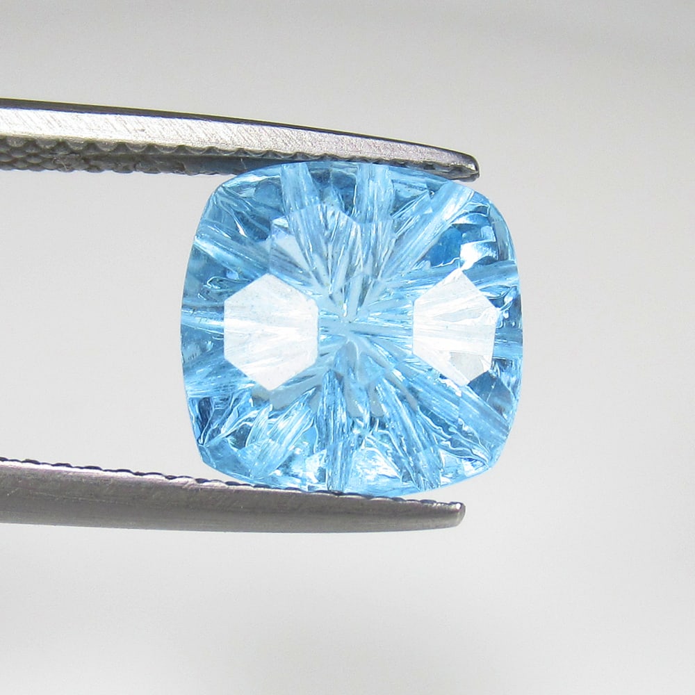 5.61 Ct Natural Blue Topaz Cushion Carving: Weight - 5.61 Ct / Size - 10.40 x 10.40 x 7.20 mm / Shape - Cushion Carving / Color - Blue / Clarity - VVS / Origin - Brazil / Treatment - Irradiated