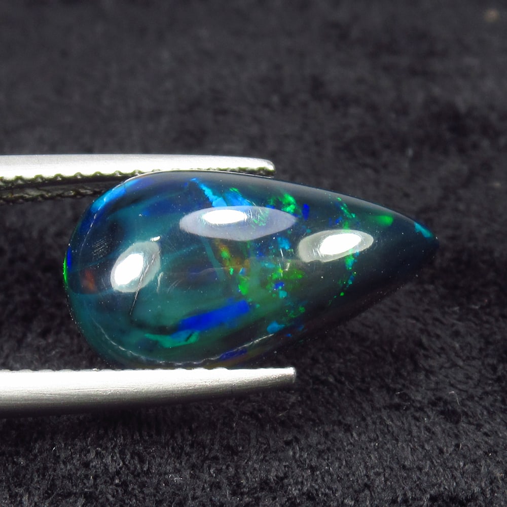 8.98 Ct Natural Black Flash Fire Opal Pear Cab: Weight - 8.98 Ct / Size - 16.80 x 9.30 x 5.70 mm / Shape - Pear Cab / Color - Black / Clarity - Translucent / Origin - Ethiopia / Treatment - Color Smoked