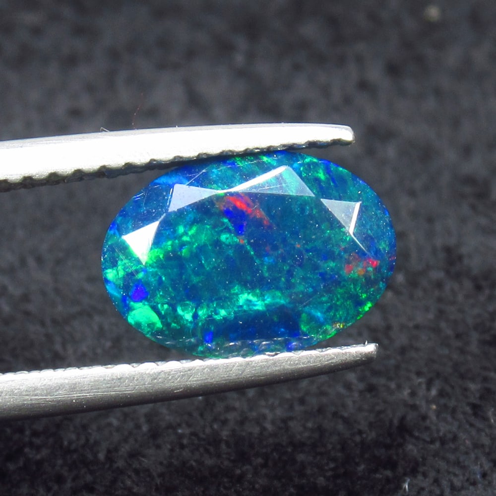 1.59 Ct Natural Black Flash Fire Opal Oval Cut: Weight - 1.59 Ct / Size - 10.50 x 7.60 x 6.00 mm / Shape - Oval Cut / Color - Black / Clarity - Translucent / Origin - Ethiopia / Treatment - Color Smoked