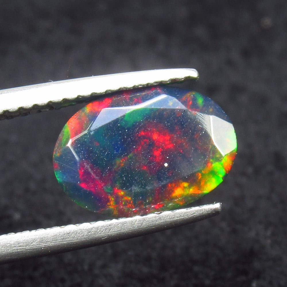 1.54 Ct Natural Black Flash Fire Opal Oval Cut: Weight - 1.54 Ct / Size - 11.30 x 8.20 x 5.20 mm / Shape - Oval Cut / Color - Black / Clarity - Translucent / Origin - Ethiopia / Treatment - Color Smoked