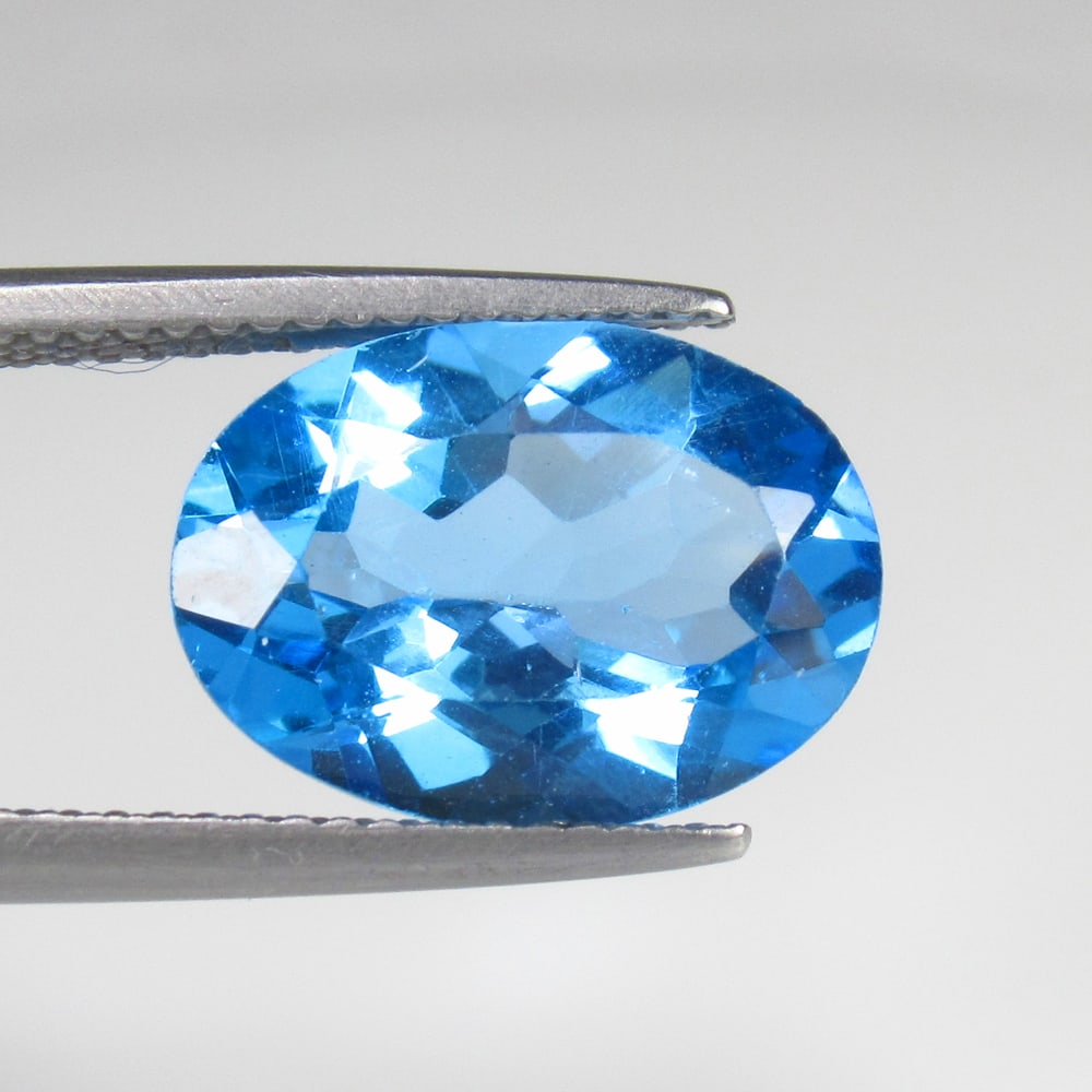 6.34 Ct Natural Blue Topaz Oval Cut: Weight - 6.34 Ct / Size - 14.30 x 10.50 x 6.50 mm / Shape - Oval Cut / Color - Blue / Clarity - VVS / Origin - Brazil / Treatment - Irradiated