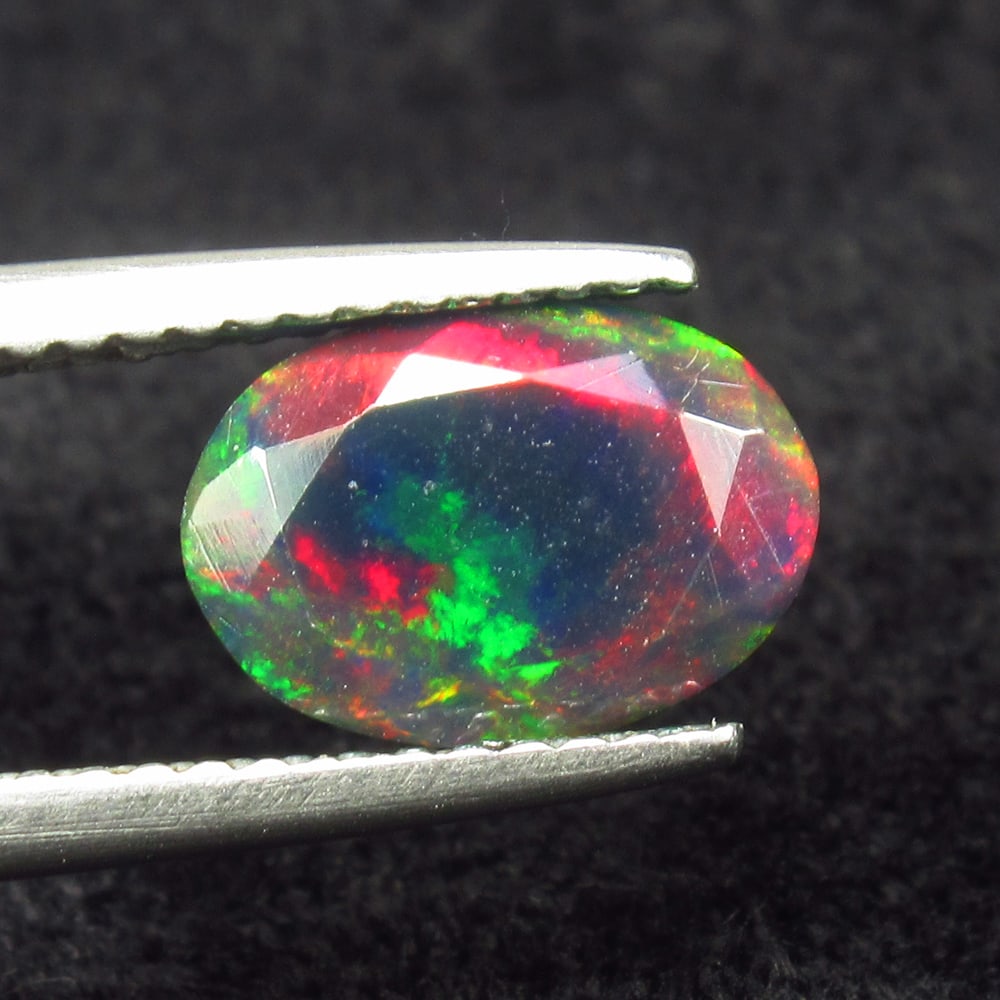 1.09 Ct Natural Black Flash Fire Opal Oval Cut: Weight - 1.09 Ct / Size - 9.30 x 6.90 x 4.80 mm / Shape - Oval Cut / Color - Black / Clarity - Translucent / Origin - Ethiopia / Treatment - Color Smoked