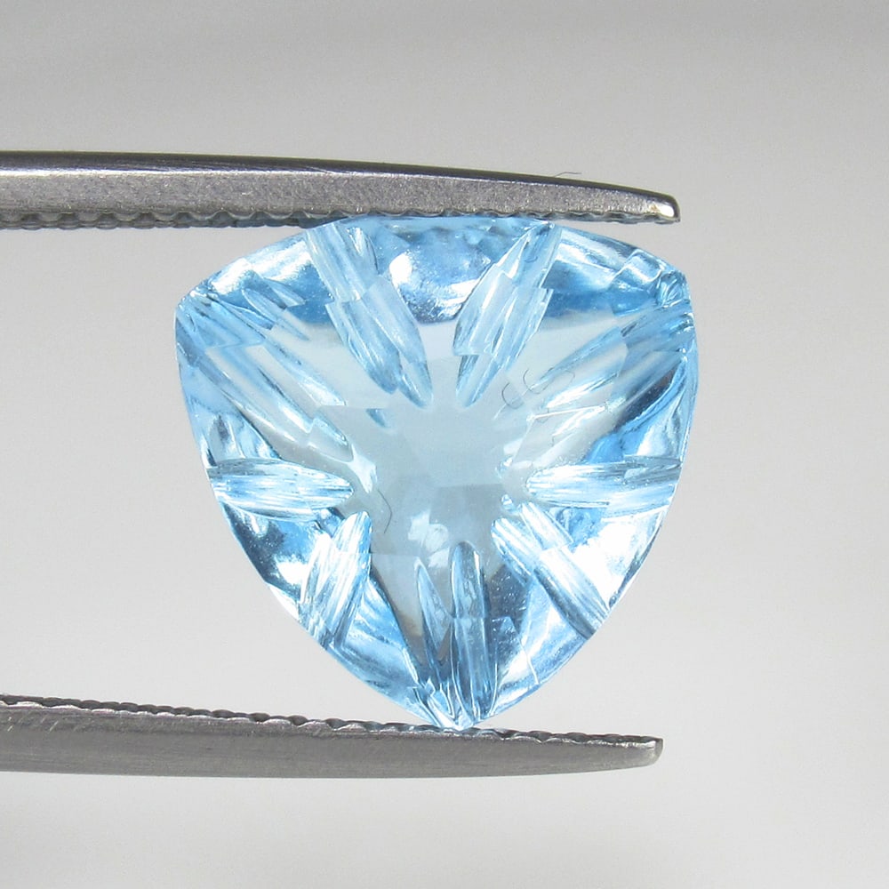 6.67 Ct Natural Blue Topaz Trillion Carving: Weight - 6.67 Ct / Size - 12.00 x 12.00 x 6.30 mm / Shape - Trillion Carving / Color - Blue / Clarity - VVS / Origin - Brazil / Treatment - Irradiated