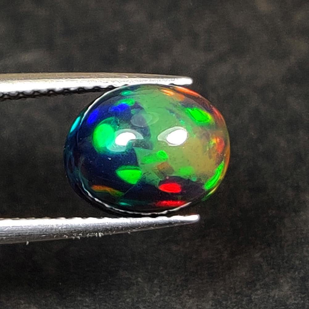 2.16 Ct Natural Black Flashing Fire Opal Oval Cab: Weight - 2.16 Ct / Dimensions - 9.40 x 7.40 x 5.90 mm / Shape - Oval Cab / Color - Black / Transparency - Translucent / Origin - Ethiopia / Treatment - Color Smoked