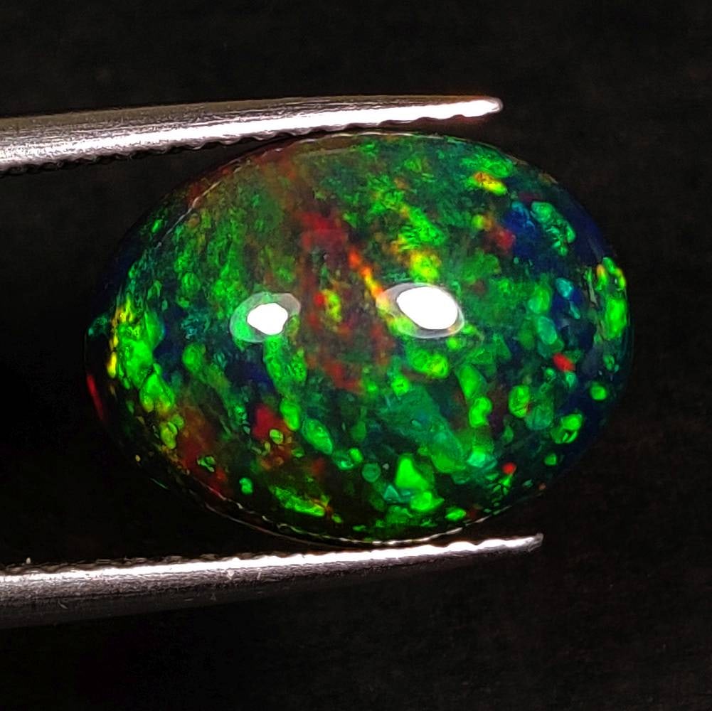 3.05 Ct Natural Black Flashing Fire "Eclipse Flame" Opal Oval Cab: Weight - 3.05 Ct / Dimensions -13.30 x 10.30 x 4.80 mm / Shape - Oval Cab / Color - Black / Clarity - Translucent / Origin - Ethiopia / Treatment - Color Smoked