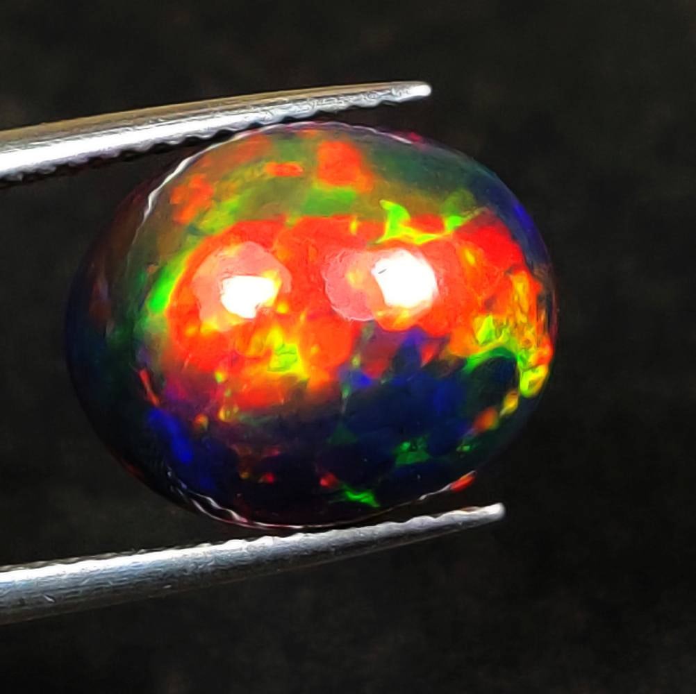 3.74 Ct Natural Black Flashing Fire "Midnight Spark" Opal Oval Cab: Weight - 3.74 Ct / Dimensions - 13.00 x 10.50 x 6.00 mm / Shape - OVal Cab / Color - Black / Clarity - Translucent / Origin - Ethiopia / Treatment - Color Smoked