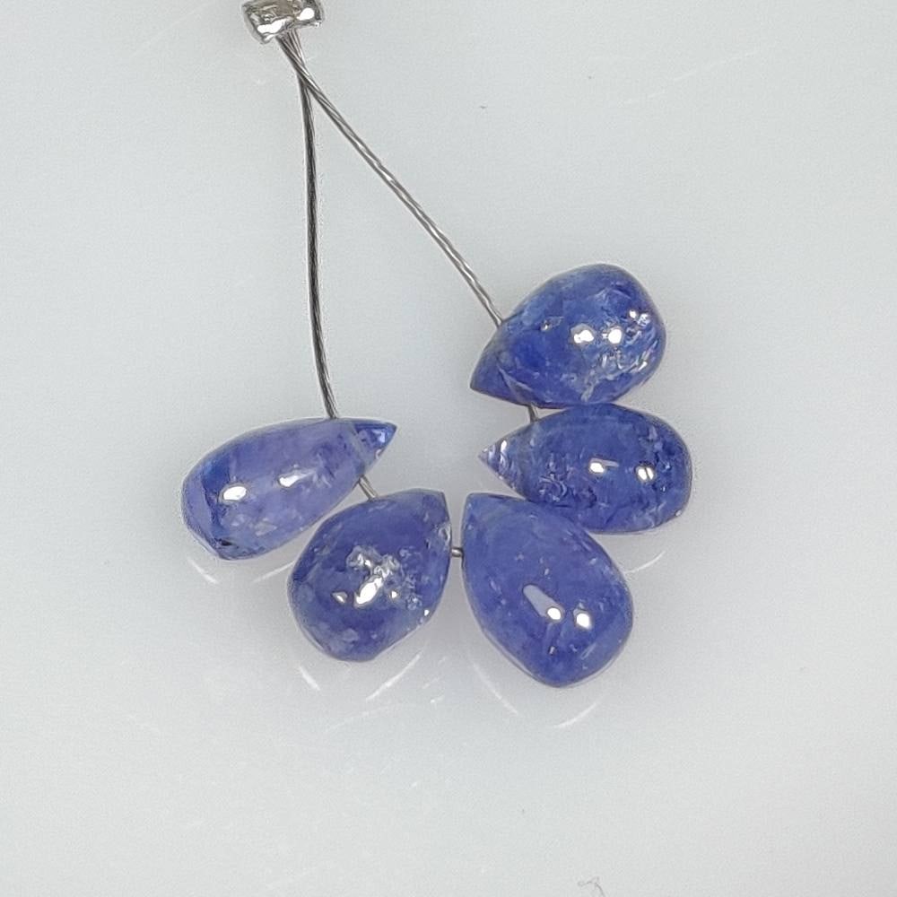 4.83 Ct Natural Tanzanite Pear Drop Beads: Weight : 4.83 Ct / Dimensions : 6.3x4.4 - 7.0x4.5 mm / 5 Pc's / Shape : Pear Drop Beads / Color : Purplish Blue / Transparency : Transparent / Treatment : Heated