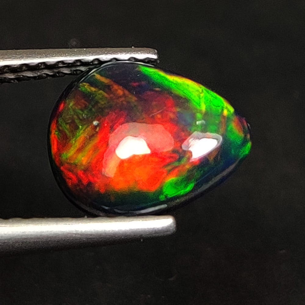 1.06 Ct Natural Black Fire Opal Pear Cab: Weight - 1.06 Ct / Size- 9.50 x 7.70 x 3.00 mm / Shape - Pear Cab / Color - Black / Clarity - Translucent / Origin - Ethiopia / Treatment - Color Smoked