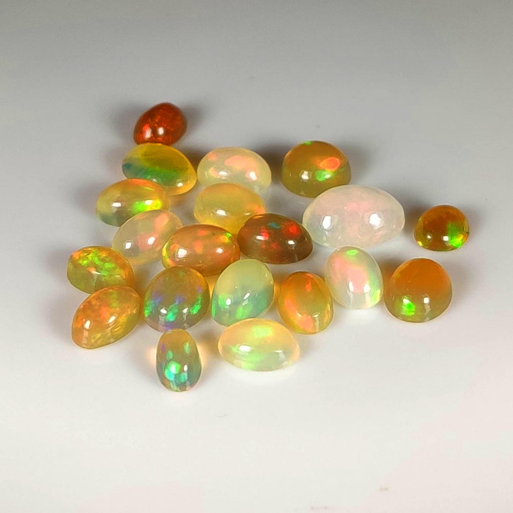 7.90 Ct Natural Multicolor Welo Opal Top Fire Oval Cab Set: Weight - 7.90 Ct / Size - 5.0x3.0 - 8.0x6.0 mm / 20 Pc's / Shape - Oval Cab / Color - Multicolor / Clarity - Translucent / Origin - Ethiopia / Treatment - None