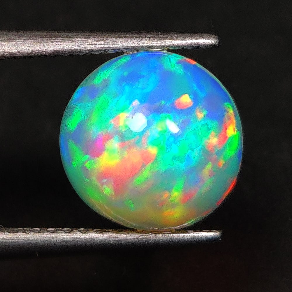 2.59 Ct Natural Multicolor Welo Fire Opal Round Cab: Weight - 2.59 Ct / Dimensions - 10.00 x 10.00 x 5.80 mm / Shape - Round Cab / Color - Multicolor / Transparency - Translucent / Origin - Ethiopia / Treatment - None