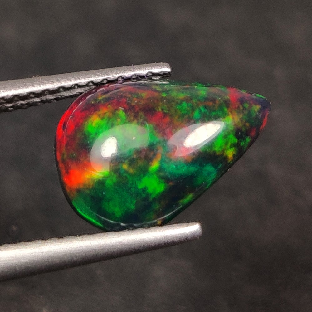 1.76 Ct Natural Black Fire Opal Pear Cab: Weight - 1.76 Ct / Dimensions - 12.70 x 9.00 x 3.90 mm / Shape -Pear Cab / Color - Black / Clarity - Translucent / Origin - Ethiopia / Treatment - Color Smoked