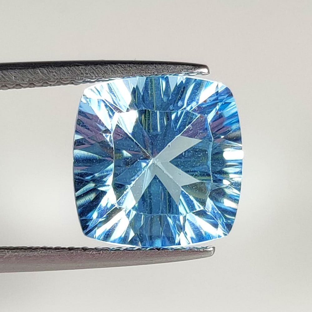 6.82 Ct Natural Blue Topaz Cushion Concave Cut: Weight - 6.82 Ct / Size - 10.70 x 10.70 x 7.00 mm / Shape - Cushion Cut / Color - Blue / Clarity - VVS / Origin - Brazil / Treatment - Irradiated