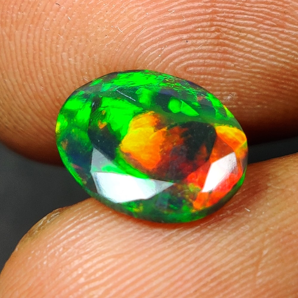 1.02 Ct Natural Black Flashing Fire Opal Oval Cut: Weight - 1.02 Ct / Size - 9.50 x 7.60 x 3.10 mm / Shape - Oval Cut / Color - Black / Transparency - Translucent / Origin - Ethiopia / Treatment - Color Smoked