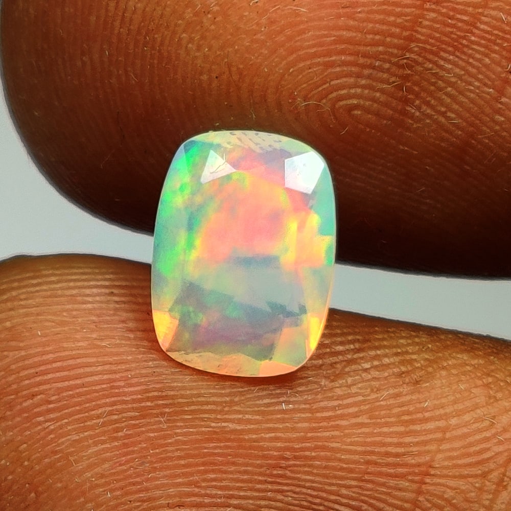 0.88 Ct Natural Multicolor Welo Opal Top Fire Cushion cut: Weight - 0.88 Ct / Size - 8.20 x 6.10 x 3.70 mm / Shape - Cushion Cut / Color - Multicolor / Clarity - Translucent / Origin - Ethiopia / Treatment - None